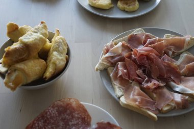 Çeşit çeşit pişirilmiş et ve yumuşak hamur işlerinden oluşan davetkar bir ziyafet, gurme ya da misafir ağırlamak için mükemmel..