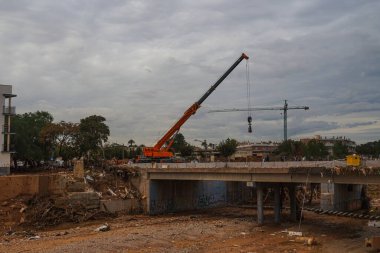 12 Kasım 2024 'te Paiporta kasabasında Valencia' lı DANA tarafından üretilen yeniden yapılanmaya başlayacak makinelerle yıkılmış poyonun geçidi. Şiddetli yağmurlarla birlikte.