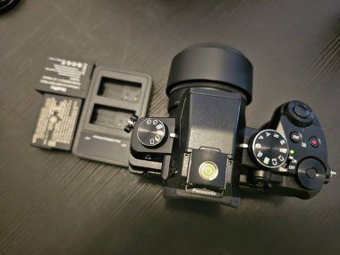 Panasonic g80 fotoğraf makinesi, artı aynı marka 25 mm lens, kameraya takılmış, şarj aleti ve iki batarya ile, 27 Kasım 2024 'te,.