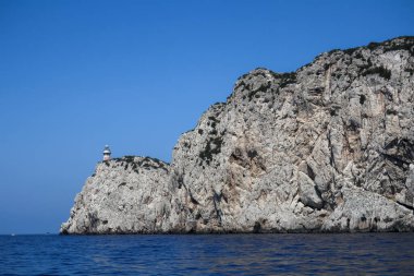 Capri Adası 'nın kayalık bölgesinde deniz feneri. Mavi gökyüzü güneşli bir gün.