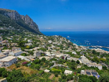 Capri 'nin bir kısmının, kentsel alanının ve limanın gözcü noktasından, çok güneşli, mavi bir yaz günü görüntüsü