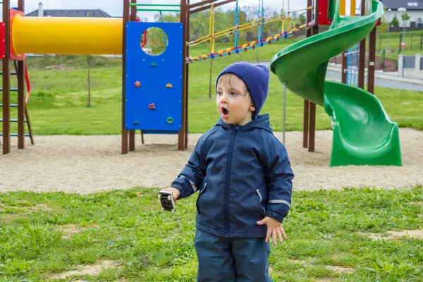 Küçük bir çocuk parkta yürüyor. Çocuk dışarıda yürümekten zevk alıyor.