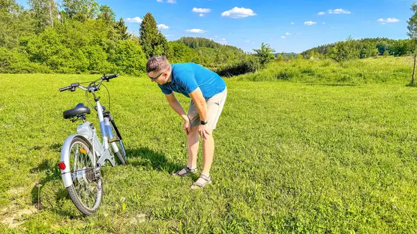 Bisikletli yakışıklı bir genç, parkta elektrikli pilli bir dağ bisikleti. Yüksek kalite fotoğraf