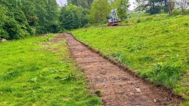 Kazıcı parkta Yeni Kaldırımlar Yapıyor. Kazı makinesi geniş kovayla çalışır. Yüksek kalite fotoğraf