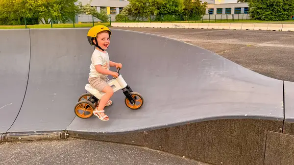 Kasklı çocuk kaykay parkında bisiklet sürmeyi öğreniyor. Yüksek kalite fotoğraf
