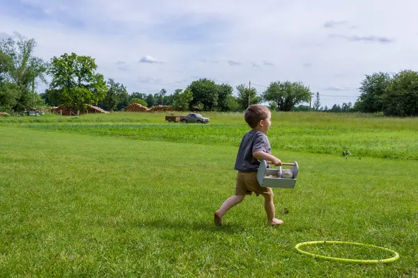 Köydeki çimlerin üzerinde yalınayak koşan küçük çocuğun arkasından bak. Yüksek kalite fotoğraf