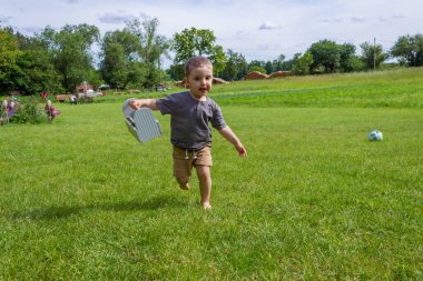 Köydeki çimlerin üzerinde yalınayak koşan küçük çocuğun arkasından bak. Yüksek kalite fotoğraf