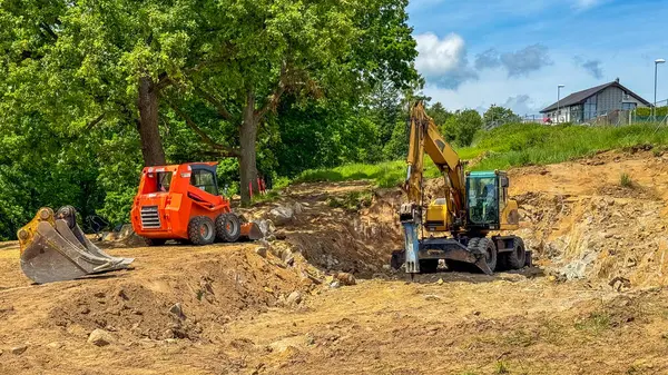 Buldozer, evin temelini kazmak için kayayı keser. Yüksek kalite fotoğraf