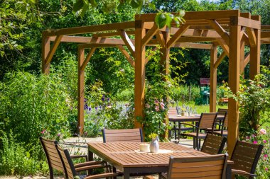Tahta teras. Sandalye, arka plandaki güzel çiçek bahçesinin masası. Yüksek kalite fotoğraf