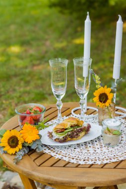 Summer table with wine and snacks fruit and croissants rustic landscape. High quality photo clipart