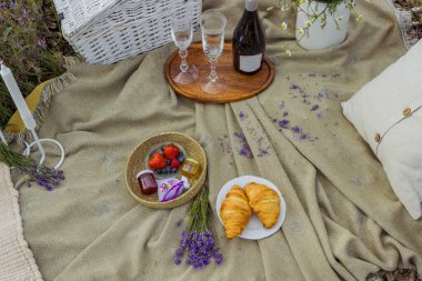 Lavanta tarlasında şarap ve peynirli yaz pikniği, açık hava, gün batımı doğal ışık. Yüksek kalite fotoğraf