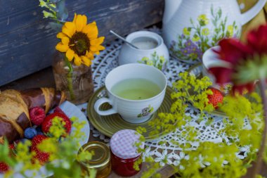 Morning summer tea with flowers and fruits on the veranda in the village house. High quality photo clipart