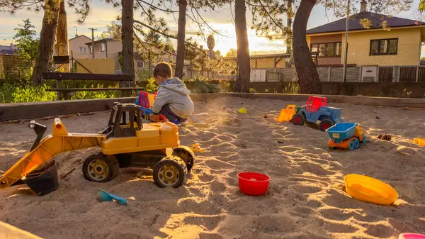 Çocuk kum havuzunda oyuncaklarla oynuyor. Çocuk kum havuzunda oyun parkında eğleniyor. Yüksek kalite fotoğraf