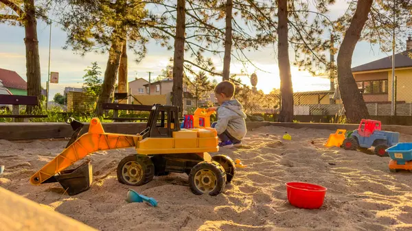 Çocuk kum havuzunda oyuncaklarla oynuyor. Çocuk kum havuzunda oyun parkında eğleniyor. Yüksek kalite fotoğraf