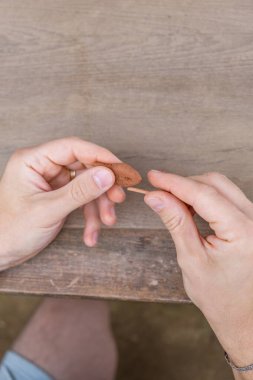 Baba ve küçük oğlu gri masada çalışıyor, kırmızı kilden şekiller yapıyorlar. Yüksek kalite fotoğraf