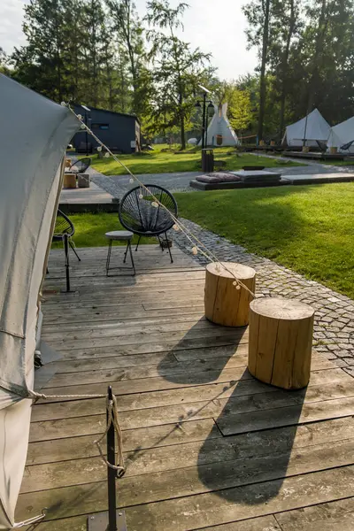 Sakin bir ormandaki çadırlar, tahta güverteler ve açık hava oturma yerleri. Yüksek kalite fotoğraf