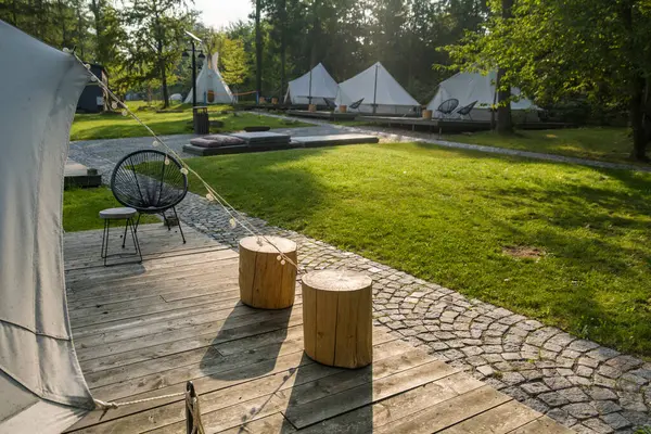 stock image Camping tents set up in a forest with wooden platforms and outdoor furniture. High quality photo