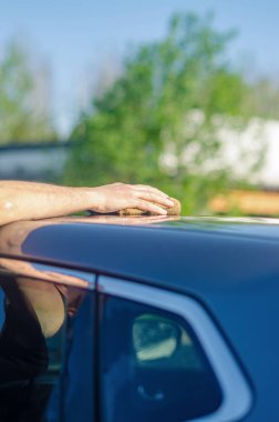 Adam dışarıda kaputu paçavrayla yıkıyor. Yüksek kalite fotoğraf