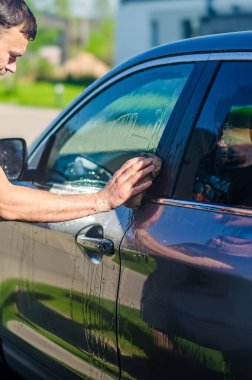 Mikrofiber bezle, araba temizleme ya da vale konseptiyle araba temizleyen bir adam. Yüksek kalite fotoğraf