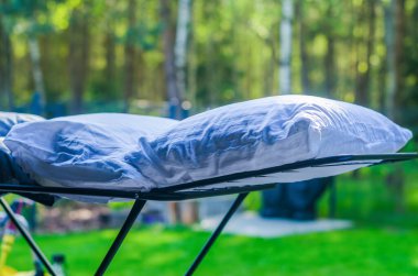 Bahçedeki açık havada iki beyaz yastık kuruyor ya da havalandırılıyor. Yüksek kalite fotoğraf