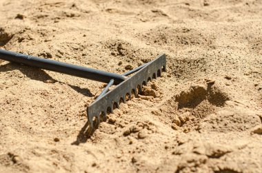 Kum Tırmığı. Tırmıkla kum temizleme. Kum plajı tenis seviyesi. Yüksek kalite fotoğraf