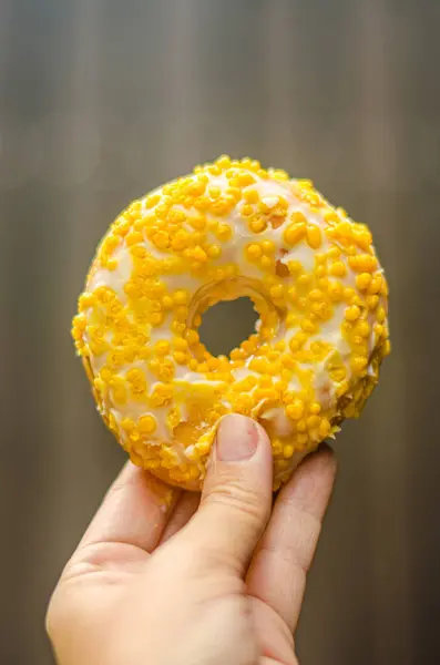 Portakal aromalı jöleli donut kaplı kadın eli. Kaliteli fotoğraf.