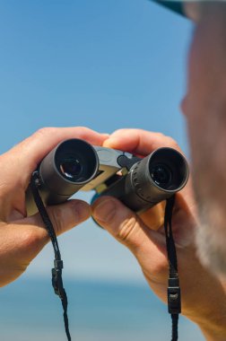 Dürbünlü eller mavi gökyüzü arka planında. Yüksek kalite fotoğraf