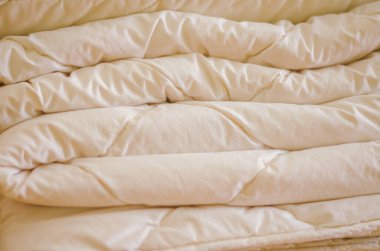 Close-up of a soft, fluffy folded white blanket with satin-like texture. High quality photo clipart