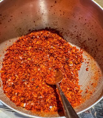 Aromatik baharat. Tabakta kırmızı biber taneleri, tahta masada kaşık ve kozalar. Yüksek kalite fotoğraf