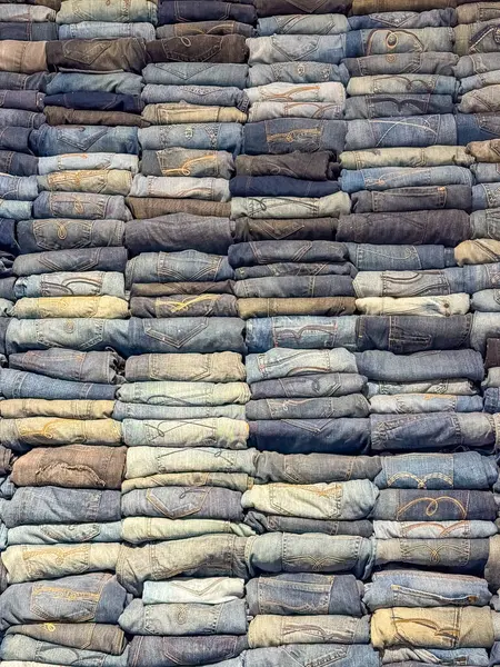 Mavinin çeşitli tonlarında katlanmış kotlar, desenli kot desenleri yaratıyor. Yüksek kalite fotoğraf