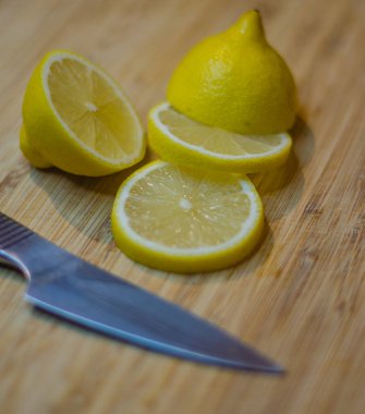 Tahta kesme tahtasının üzerinde limon ve gümüş bıçak kesimi. Yüksek kalite fotoğraf