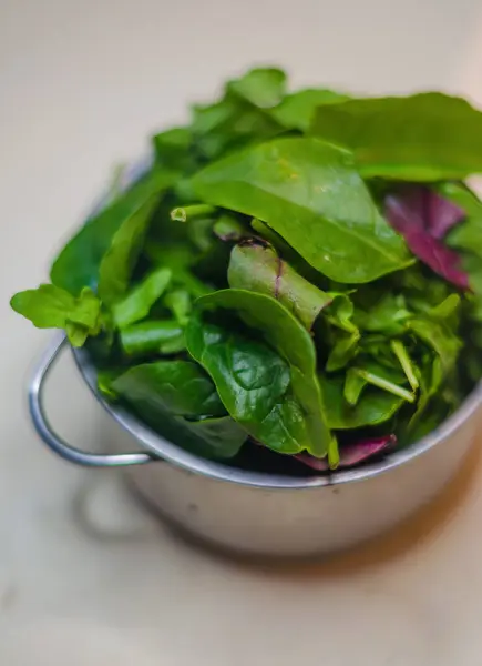 Bej arka planda metal tencerede taze yeşil salata. Yüksek kalite fotoğraf