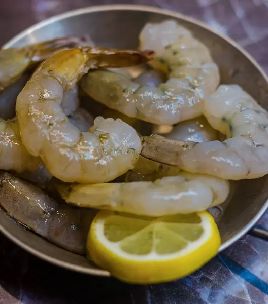 Gri arka planda çiğ karides, karides ve bir dilim limon. Yüksek kalite fotoğraf