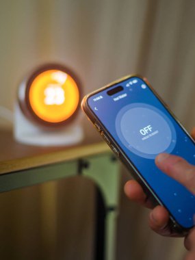 Smartphone Kontrol Termostatı Dijital Sıcaklık Ekranı ile el ele tutuşuyor. Yüksek kalite fotoğraf