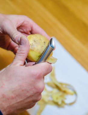 Sebze soyucusuyla patates soyan birinin yakın çekimi. Yüksek kalite fotoğraf