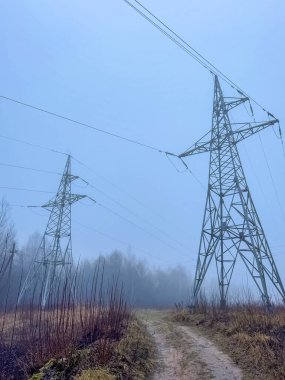 Sisli arazide elektrik kuleleri ve olay yerinden geçen toprak bir patika. Yüksek kalite fotoğraf