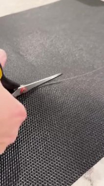 Erkek eli makasla evde siyah hasırı kesiyor. Yüksek kaliteli FullHD görüntüler