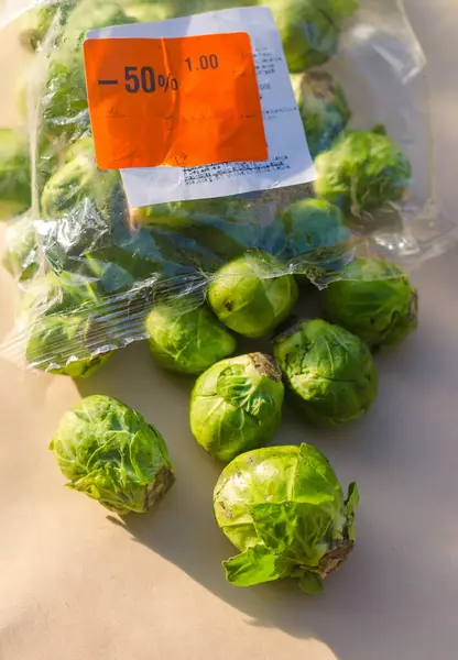 İndirim etiketli plastik bir torbadan Brüksel lahanası dökülüyor. Yüksek kalite fotoğraf
