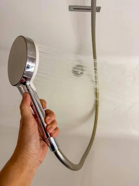 Duş başlığını tutmak, su akışı, banyo kapanışı. Yüksek kalite fotoğraf