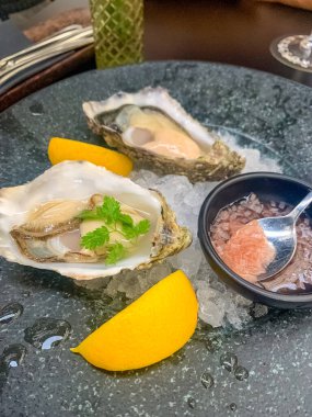 Buzlu taze istiridye, limon dilimleri, gurme deniz ürünleri, güzel yemekler. Yüksek kalite fotoğraf