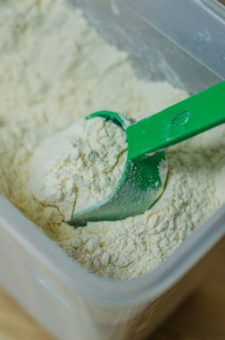 Yeşil kepçe, yiyecek deposu ve mutfak detaylarıyla dolu temiz bir kapta un. Yüksek kalite fotoğraf