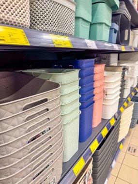 Organized shelves with various plastic storage baskets in different colors and sizes in a retail store. High quality photo clipart