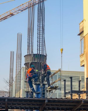 İnşaat işçileri yüksek katlı bir inşaat sahasında inşaat demirleri oluşturuyorlar. Yüksek kalite fotoğraf