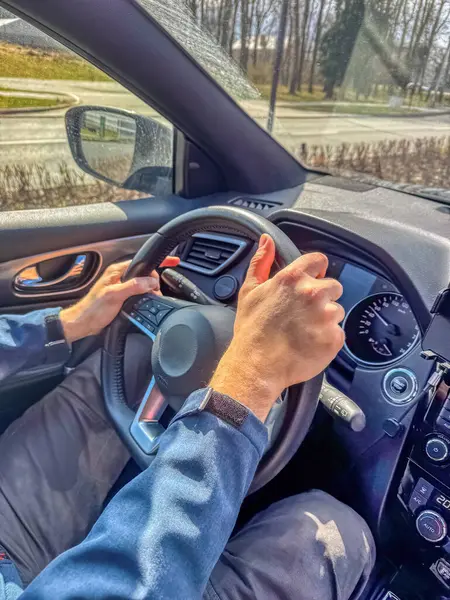 Sürücü elleri, güneşli bir günde araba içinde direksiyonda ve yol manzaralı. Yüksek kalite fotoğraf