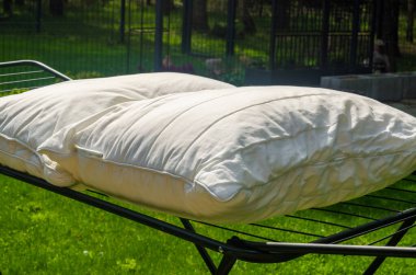 Beyaz yastıklar yaz günü açık havada güneş ışığında yeşil çimlerin üzerinde kururlar. Yüksek kalite fotoğraf