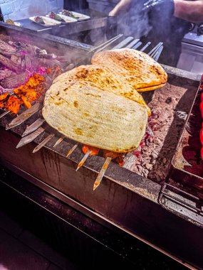 Canlı bir mutfak ortamında flatekalar sıcak kömürlerin üzerinde ızgara ediliyor. Yüksek kalite fotoğraf