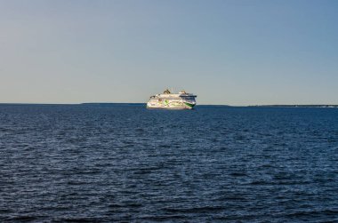 Açık denizde, açık mavi gökyüzü ufkunun altında ilerleyen beyaz feribot gemisi. Yüksek kalite fotoğraf
