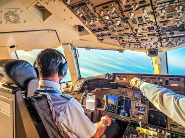 Pilotlar okyanus üzerinde uçuyor, pilot kabinini kontrol ve ekranlarla görüyor. Yüksek kalite fotoğraf