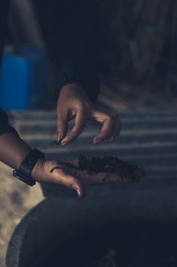 Earthworm in hand with dark background clipart