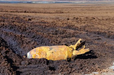 Savaştan arta kalan patlamamış bir bomba dışarıda uzanıyor. İnsanların sağlığı ve hayatı için büyük bir tehdit oluşturuyor.